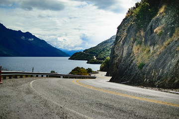 Scenic Countryside Road alongside Mountains and a Lake in New Zealand by Queenstown