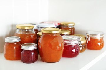 Fototapeta na wymiar Jars with different sweet jam on table