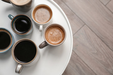 Many cups of different aromatic hot coffee on table, top view