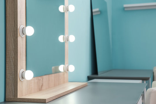 Makeup mirror with light bulbs on table in dressing room