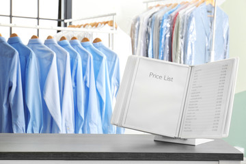 Workplace of receptionist with price list at dry-cleaner's