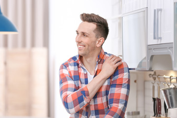 Obraz premium Portrait of handsome young man in kitchen