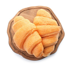 Wooden board with tasty croissants on white background, top view