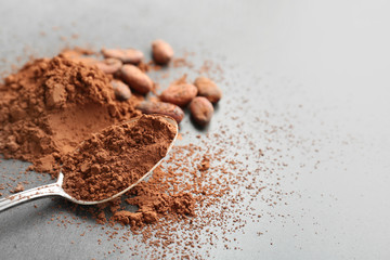 Composition with cocoa powder and beans on grey background