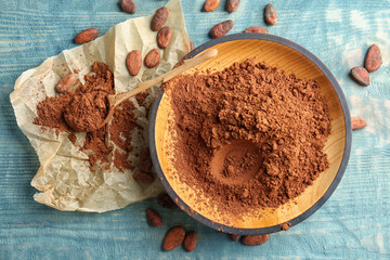 Flat lay composition with cocoa powder and beans on wooden background