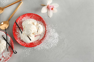 Plate with tasty vanilla ice cream on grey background, top view