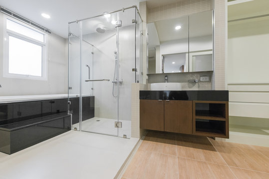 Master bathroom interior with walk in shower and white vanity cabinet