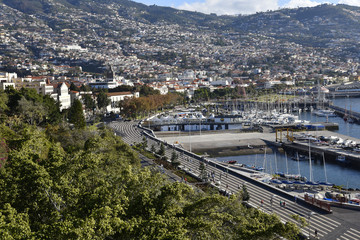 View over the city of Funchal.Funchal is the Capital of the island of Madeira. The distinctive houses and roofs seem to pile on top of each other as the land rises steeply from the Atlantic Ocean.