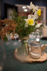 Yellow and White Spring Flower Centerpiece in a Glass Canning Jar on a Wooden Slab