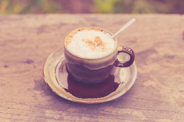 Cappuccino coffee on old wooden table