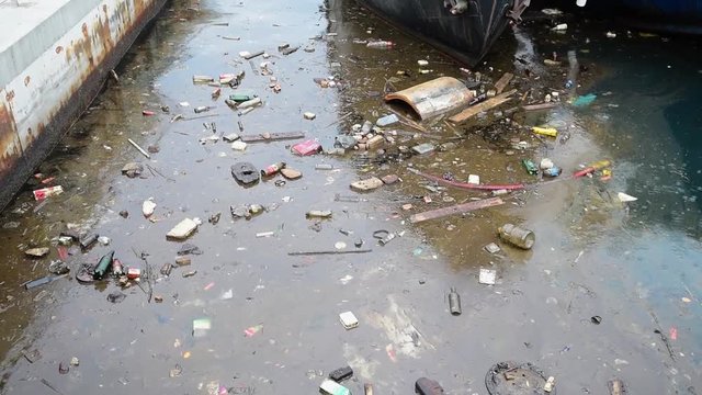 Water pollution old garbage and oil patches on sea surface.