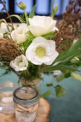 Yellow and White Spring Flower Centerpiece in a Glass Canning Jar on a Wooden Slab