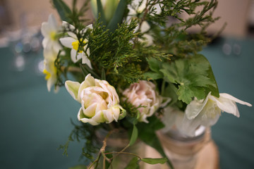 Yellow and White Spring Flower Centerpiece in a Glass Canning Jar on a Wooden Slab