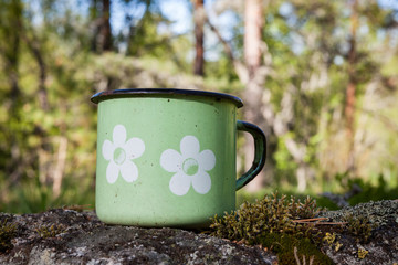 Obraz premium Enamel porcelain mug in summer nature