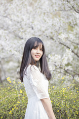 Beautiful girl enjoying the spring flower outdoors in the park