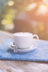 Coffee espresso on wood table nature background in garden,warm tone