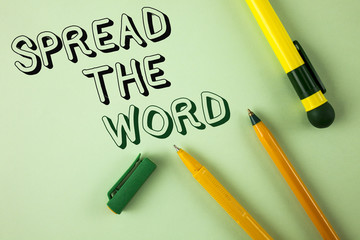 Word writing text Spread The Word. Business concept for Run advertisements to increase store sales many fold written on Plain Green background Pens next to it.