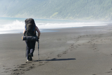 Young woman backpacker  on the Lost Coast backpacking trail in California