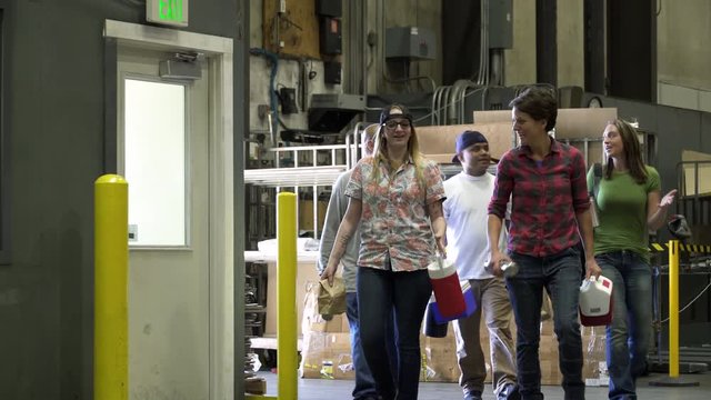 Group of people walking through warehouse carrying packed lunch