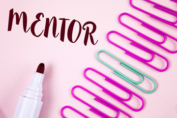 Writing note showing  Mentor. Business photo showcasing Person who gives advice or support to a younger less experienced written on Plain Pink background Marker and Paper Pins next to it.