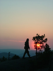 Silhouette of a man on mountain top at sunset background.