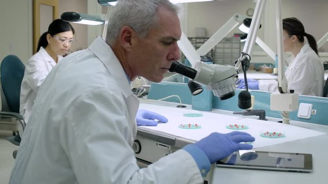 Doctor examining samples through a microscope