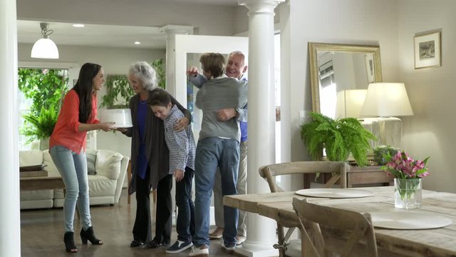 Grandparents being greeted by family.