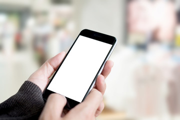 Male hand holding smartphone at cloth shop. Blank screen mobile phone for graphic display montage