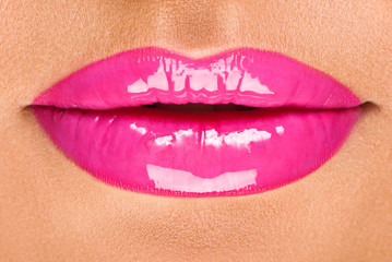 young woman's beautiful lips with pink glossy lipstick