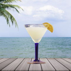 Cocktail glasses with sea background.