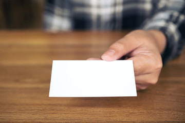 Obraz premium Business woman holding and giving an empty business card to someone on table in office