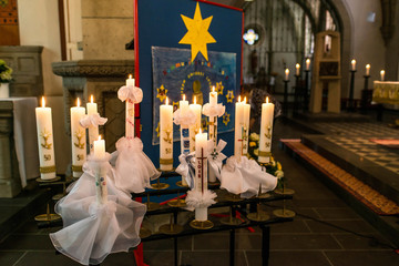 First holy communion or confirmation burning candles rowed up in church before ceremony beautiful...