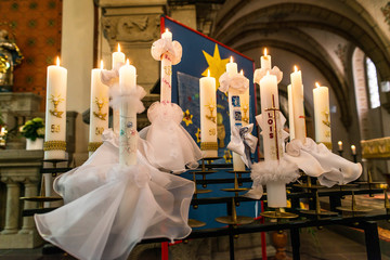 First holy communion or confirmation burning candles rowed up in church before ceremony beautiful...