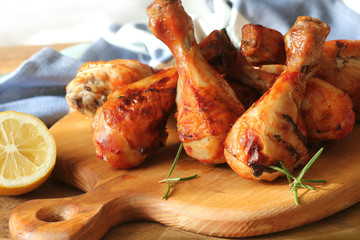 Grilled chicken legs on cutting board. Rustic background
