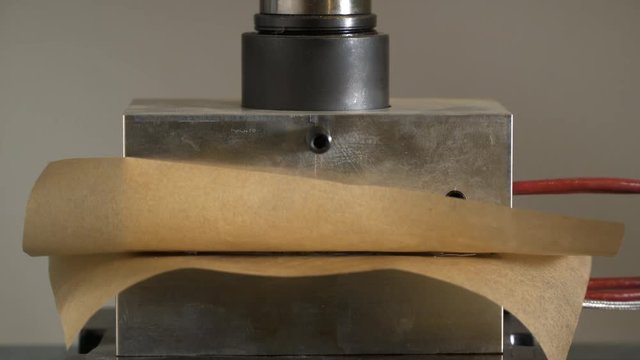 Process of marijuana being melted and checked in rosin press, timelapse.