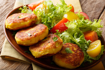 Homemade Ecuadorian potato pancakes with fresh vegetable salad close-up on a plate on a table. horizontal