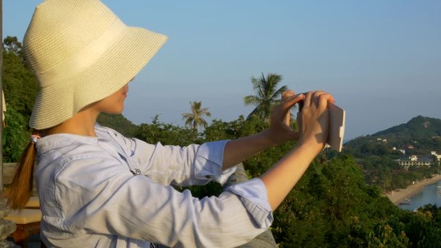 Girl in tropical islands shoots on phone.