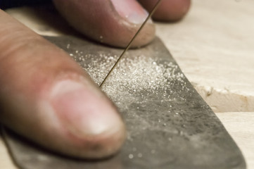 Jewelry maker cutting sterling silver with a band saw