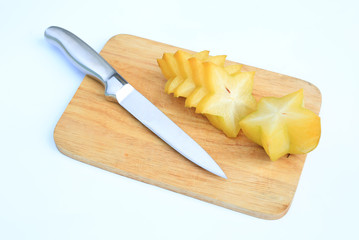 Sliced ripe Star apple on wood board background against white background.
