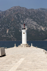 Fototapeta na wymiar Perast, Montenegro - August 04, 2017: Sea lighthouse on the island of Gospa-od-Shkrpjela in the Bay of Kotor