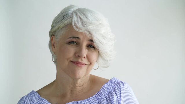 Woman with short hair shaking and nodding her head, studio shot.