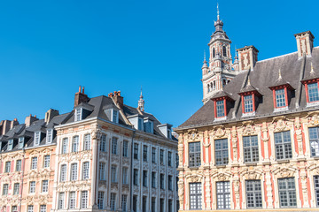 Fototapeta na wymiar Lille, old facades in the Grand-Place, the belfry of the Chambre de Commerce in background 