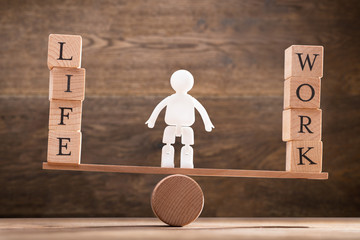 Human Figure Standing Between Work And Life Wooden Blocks