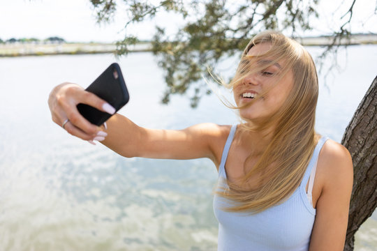 Teenage girl taking a selfie with hair in front of face