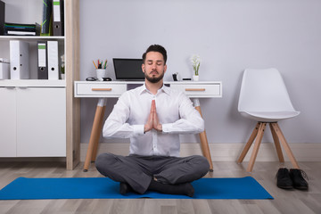 Businessman Meditating In Office