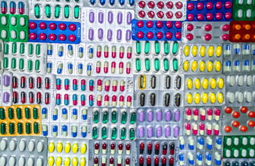 Top view of colorful tablets and capsule pills in blister packaging arrange with beautiful pattern. Pharmaceutical industry concept. Full frame pills background. Global pharmaceuticals