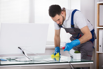 Male Worker Cleaning Office Desk