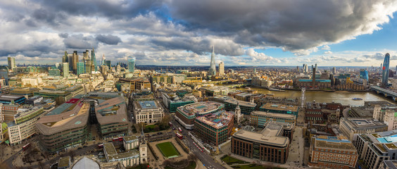 London, England - Panoramic skyline view of London. This view includes the skyscrapers of Bank District, Tower Bridge, Shard skyscraper and Millennium Bridge. Beautiful dramatic clouds and sunshine