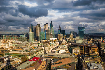 London, England - Panoramic skyline view of Bank and Canary Wharf, central London's leading financial districts with famous skyscrapers and other landmarks at golden hour sunset. Dramatic sky behind