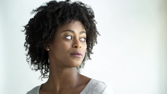 Confident young woman with afro smiling , studio shot.